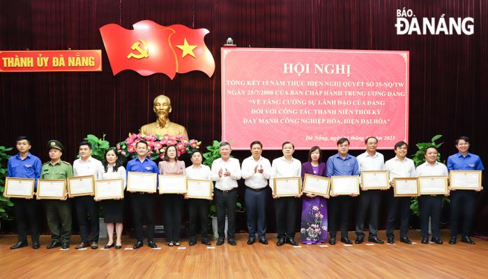 Phó Bí thư Thường trực Thành ủy Lương Nguyễn Minh Triết (thứ 8, phải sang) và Trưởng ban Dân vận Thành ủy Lê Văn Trung (thứ 8, trái sang) trao bằng khen của Chủ tịch UBND thành phố cho 14 tập thể có thành tích xuất sắc trong thực hiện Nghị quyết số 25-NQ/TW. Ảnh: NGỌC PHÚ