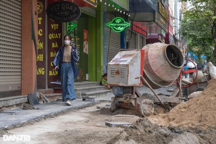 Thùy Trang, sinh viên năm 2 Đại học Quốc gia Hà Nội len lỏi đi qua nhiều vật liệu, máy móc đang thi công trên vỉa hè phố Trần Nhân Thông. Trang cho biết, em cảm thấy khá khó khăn khi đi qua đây, nhiều lúc phải kiếm lối xuống lòng đường để đi dù rất đông xe cộ.
