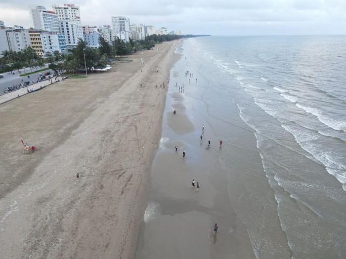 Bãi biển dài tít tắp lưa thưa vài bóng người.