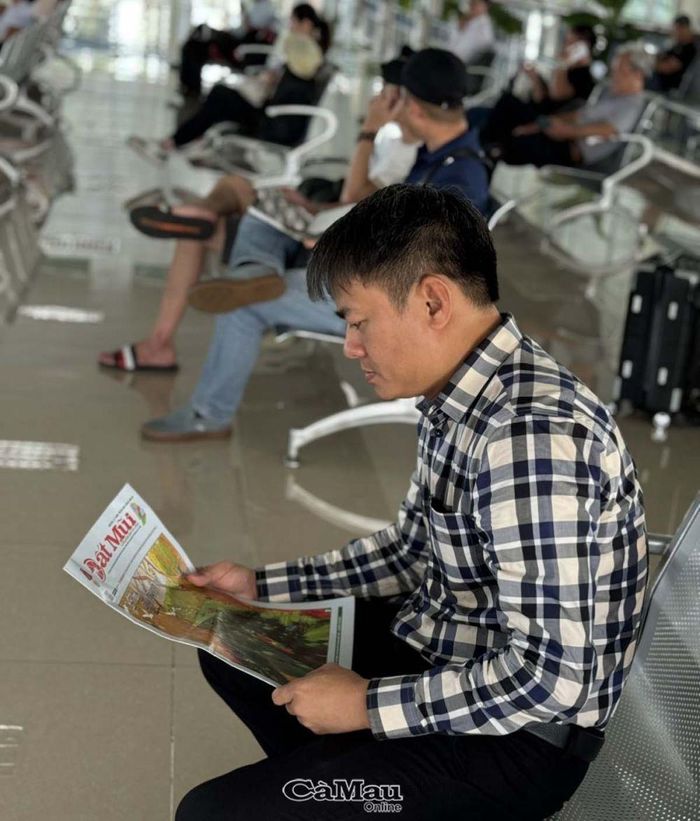 Một hành khách đọc Báo Cà Mau trong thời gian chờ làm thủ tục bay, tại phòng chờ Sân bay Cà Mau.