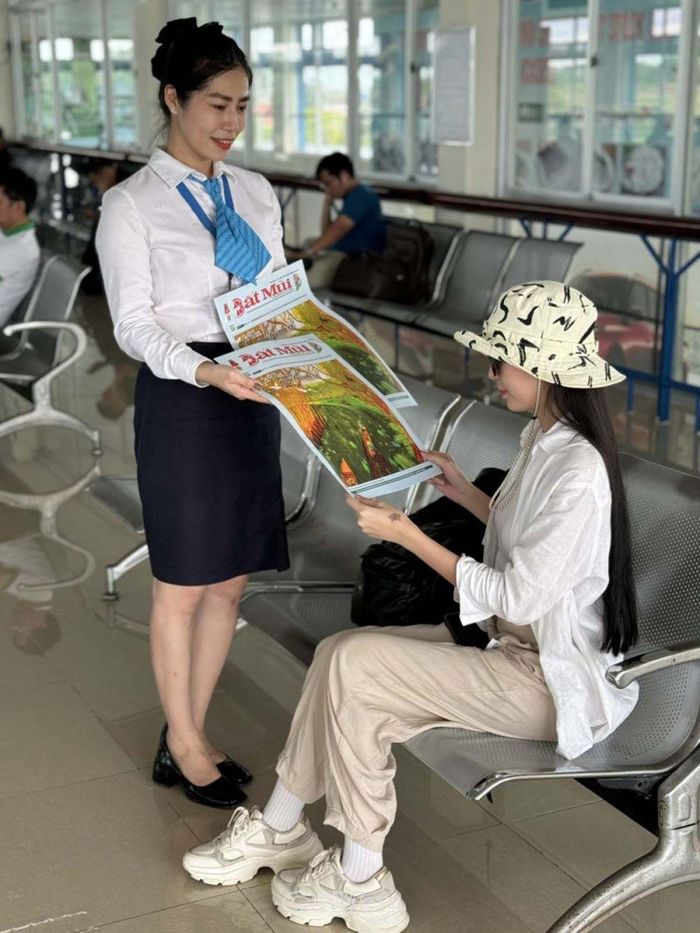 Nhân viên Sân bay Cà Mau phát phục vụ ấn phẩm Báo Cà Mau cho hành khách đang chờ bay.