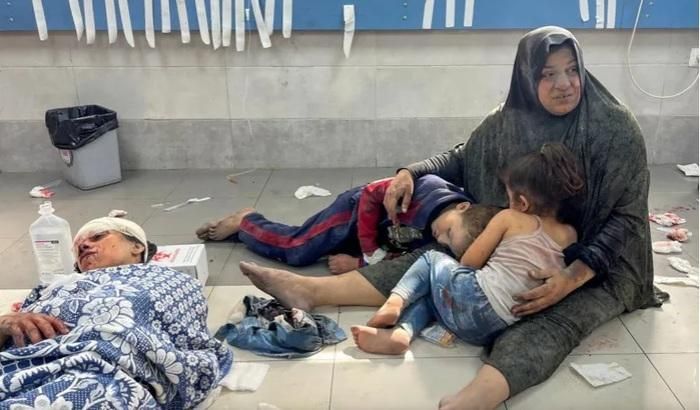 Một phụ nữ Palestine bế các con tại Bệnh viện Al-Shifa ở Thành phố Gaza vào ngày 23 tháng 10 năm 2023, sau một cuộc không kích của Israel khiến cả gia đình bị thương. Ảnh: Reuters