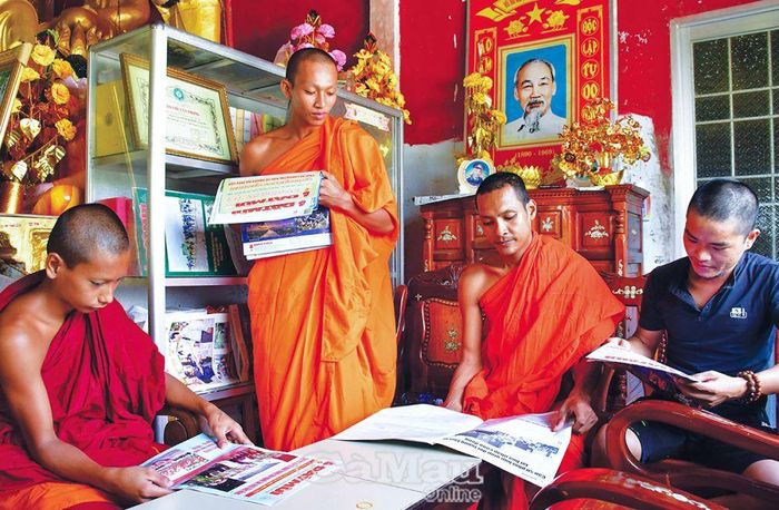 Nhà sư và phật tử đọc báo tại chùa Rạch Cui, xã Khánh Bình Ðông, huyện Trần Văn Thời. Ảnh: MỘNG THƯỜNG