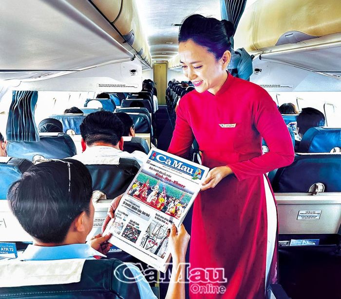 Tiếp viên hàng không phát ấn phẩm báo Cà Mau cho hành khách đi trên chuyến bay. (Ảnh do Chi nhánh Tổng công ty Hàng không Việt Nam - CTCP tại Cà Mau cung cấp)