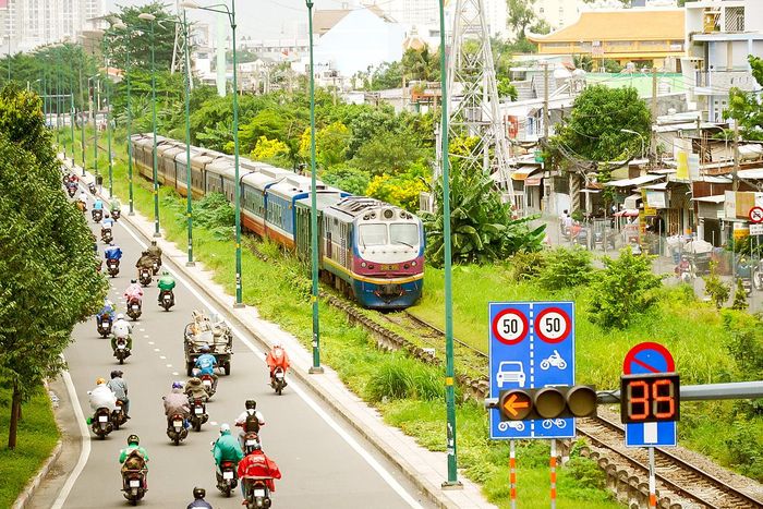  Xe lửa di chuyển song song trên trục đường Kha Vạn Cân TP Thủ Đức, TPHCM. Ảnh: HOÀNG HÙNG 