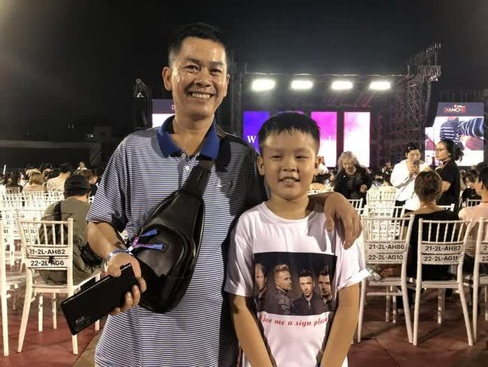 Anh Phan Phi Vũ, 44 tuổi (trái) cùng con trai là bé Phi Sơn (phải) đến tham dự đêm diễn đầu tiên của Westlife tại TP.HCM. Ảnh: Anh Thư