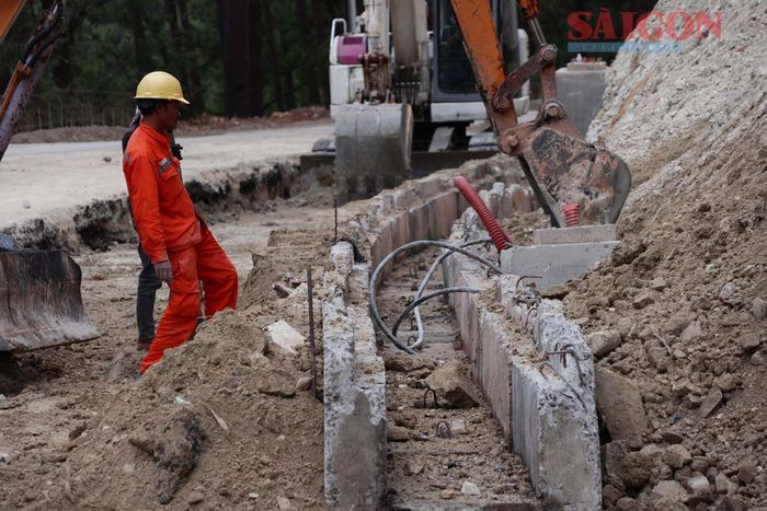  Công nhân thi công phần mương thoát nước và ngầm hóa đường điện trên đèo Prenn. Ảnh: ĐOÀN KIÊN 