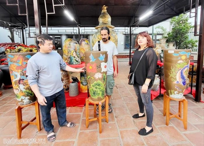 Tác phẩm Nguyễn Trường Thọ - Nhà tạo mẫu khuân, cốt gốm; Mathias- Nhiếp ảnh người Đức; Quỳnh Anh - doanh nhân làng Kim Lan đang chiêm ngưỡng những tác phẩm đặc sắc và những ý tưởng kết nối đưa sản phẩm Kim Lan ra thị trường trong và ngoài nước. (Ảnh: Minh Hòa).