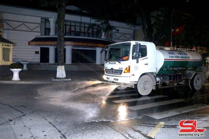 Công nhân Xí nghiệp Môi trường đô thị tưới nước làm sạch bụi bẩn trên tuyến đường Hoa Ban, Thành phố.