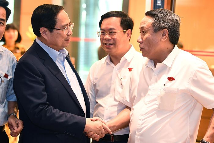 Thủ tướng Phạm Minh Chính trao đổi với Đại biểu Hà Sỹ Đồng bên hành lang Quốc hội. Ảnh: Hoàng Hà