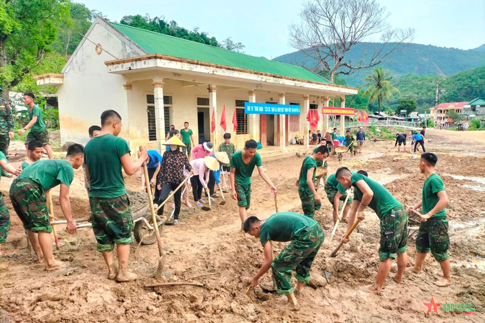 Cán bộ, chiến sĩ Trung đoàn 1 giúp địa phương khắc phục hậu quả mưa lũ. 