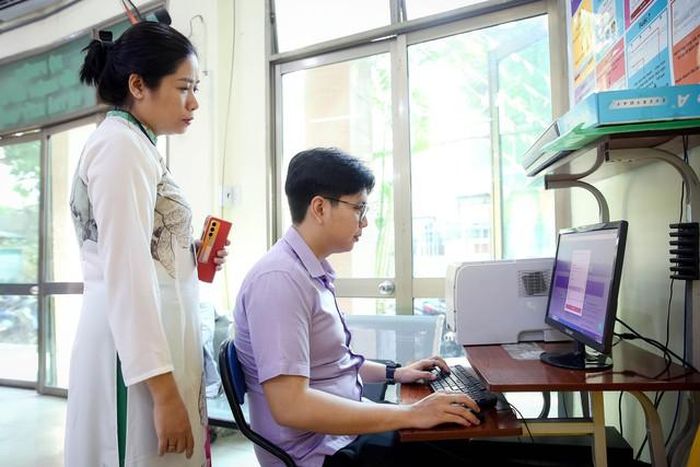 Cán bộ UBND phường 12 (quận 10, TP HCM) hướng dẫn người dân làm thủ tục hành chính qua hệ thống dịch vụ công trực tuyến Ảnh: HOÀNG TRIỀU