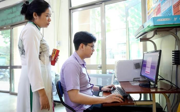 Cán bộ UBND phường 12 (quận 10, TP HCM) hướng dẫn người dân làm thủ tục hành chính qua hệ thống dịch vụ công trực tuyến Ảnh: HOÀNG TRIỀU