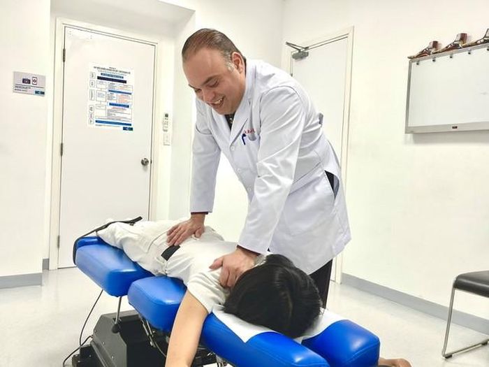 Bác sĩ Rob Sleiman điều trị thoát vị đĩa đệm cho bệnh nhân (Ảnh: Ngọc Đoàn)