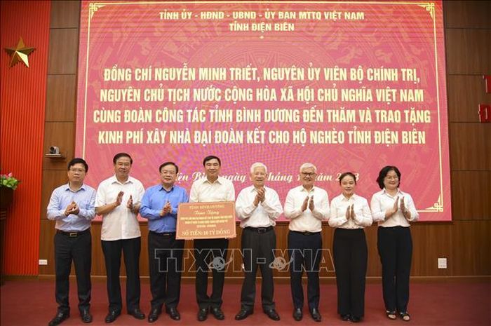Nguyên Chủ tịch nước Nguyễn Minh Triết cùng đoàn công tác tỉnh Bình Dương trao tượng trưng kinh phí xây dựng nhà Đại đoàn kết cho tỉnh Điện Biên. Ảnh: Xuân Tư/TTXVN