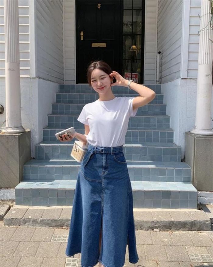 Chân váy jeans cũng là item vừa trẻ trung vừa kín đáo mà nàng công sở có thể diện hàng ngày. Cô nàng này chọn diện chân váy jeans dáng dài mix cùng sơ mi trắng tạo cảm giác cổ điển mà vẫn trẻ trung. Cô mang thêm túi xách bằng cói thú vị.