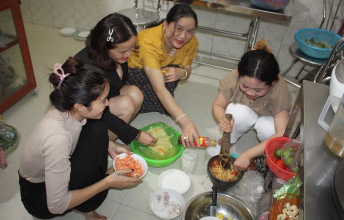 Châu Anh (ngoài cùng bên trái) trổ tài làm món ăn truyền thống Lào là đu đủ trộn để đãi khách Việt.