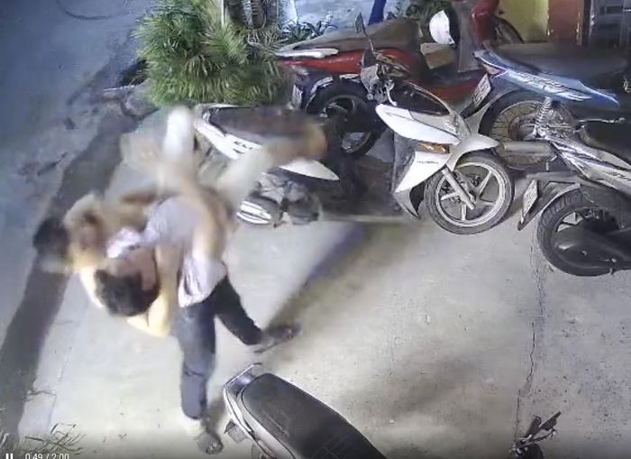 Đối tượng Phan Thanh Tùng bồng anh Đạt ném xuống đất. Ảnh chụp lại video.