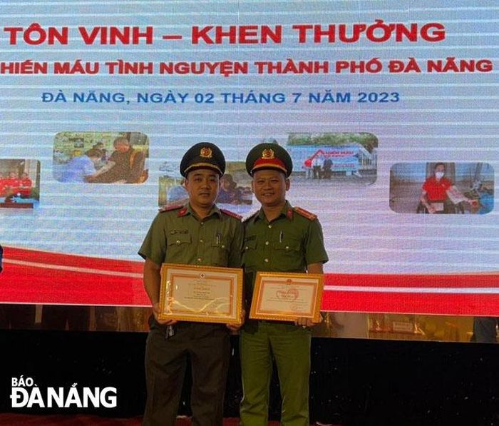 Trung úy Trương Đình Việt (bên trái) nhận Bằng khen tại Lễ Tôn vinh - Khen thưởng hiến máu tình nguyện năm 2023.