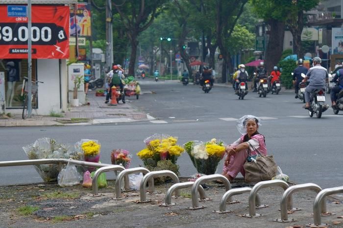 Những đóa hoa tươi được bày bán trước cổng Tao Đàn dưới trời mưa bụi lất phất.