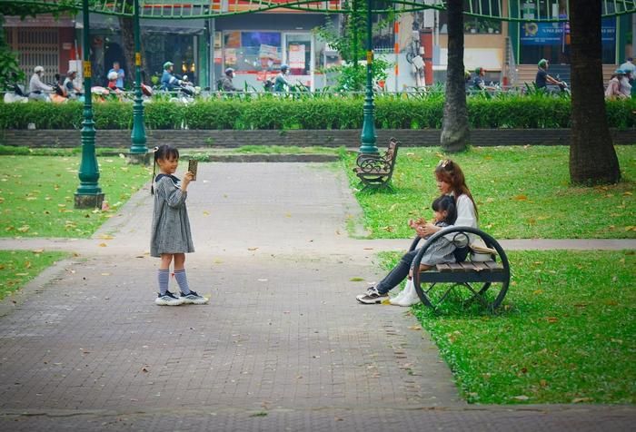 Khoảnh khắc dễ thương của người mẹ và 2 con gái trong không khí dịu mát của buổi sớm. Nơi đây được ví như lá phổi xanh của Thành phố với các mặt tiền đường Nguyễn Thị Minh Khai, Cách Mạng Tháng Tám, Nguyễn Du và Huyền Trân Công Chúa.