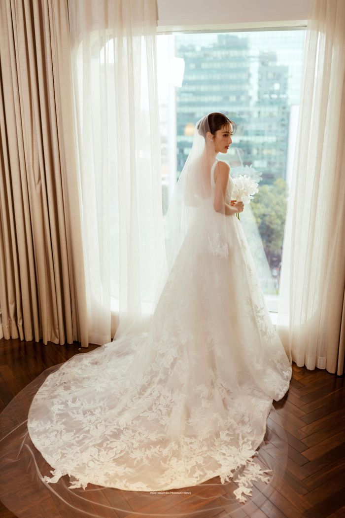 Diễm My xinh đẹp trong chiếc váy cưới được thiết kế tinh xảo với phần cổ khoét sâu. Theo tiết lộ trước đó của đại diện Diễm My 9X, cô sẽ có tiết mục đặc biệt cùng Khả Ngân, Ái Phương, Trang Hý... trong ngày vui. Đây là món quà nữ diễn viên dành tặng ông xã và khách mời.