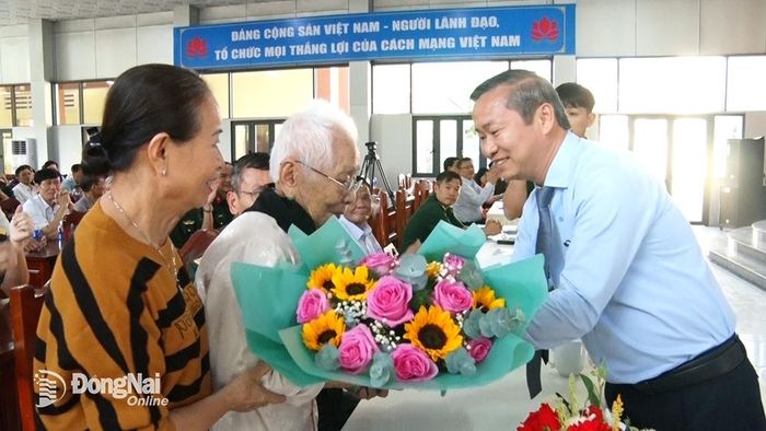Bí thư Huyện ủy Thống Nhất Cao Tiến Sỹ tặng hoa cho Mẹ Việt Nam anh hung Trần Thị Ngọc Anh tại buổi gặp mặt