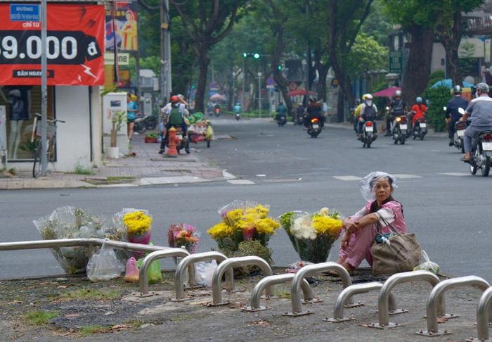 Những đóa hoa tươi được bày bán trước cổng Tao Đàn dưới trời mưa bụi lất phất.