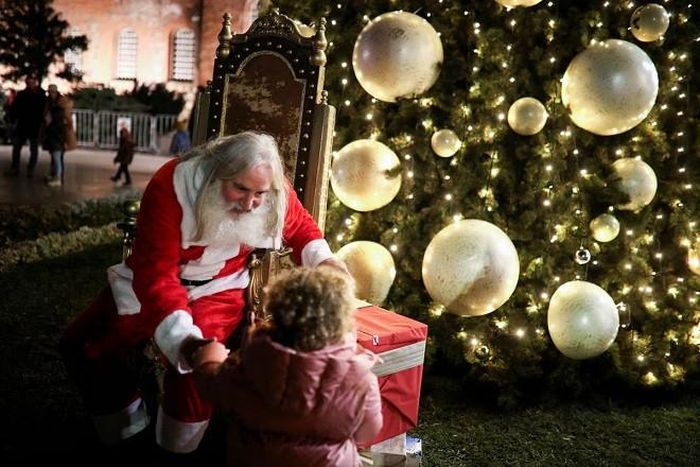Ông già Noel trò chuyện với trẻ nhỏ trước nhà thờ Alexander Nevsky ở Sofia, Bulgaria. Ảnh: Reuters