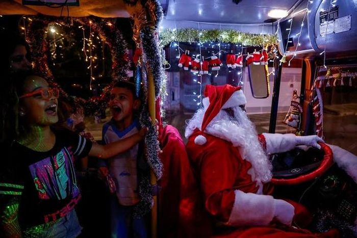 Một nghị viên ở Brazil mặc trang phục ông già Noel lái xe chở trẻ em đi hát tại Jardim Alzira Franco, Santo Andre. Ảnh: Reuters