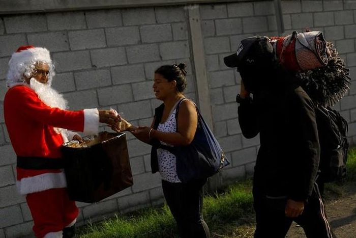 Ông già Noel tặng kẹo cho những người di cư ở Piedras Negras, Coahuila, Mexico. Ảnh: Reuters