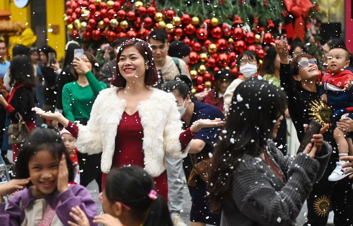 Người dân trải nghiệm tuyết rơi tại phố đi bộ Khu đô thị Hạ Đình (quận Thanh Xuân).