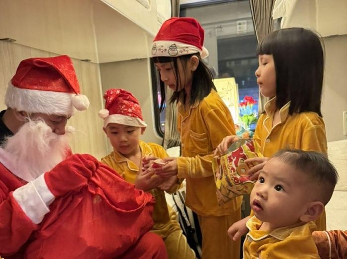 Các em nhỏ vây quanh ông già Noel đợi nhận quà.