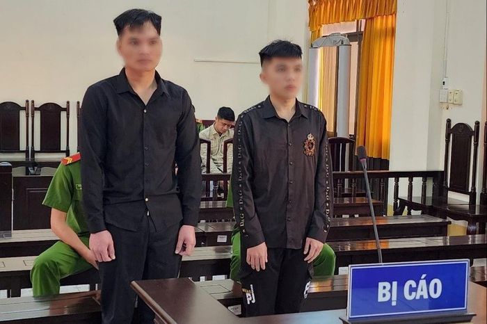 Hai bị cáo Quảng và Lợi (từ trái sang) tại phiên tòa.