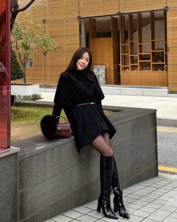 Nếu muốn ghi điểm, bạn có thể học nàng blogger này diện váy len dáng oversized mix cùng quần tất đen, boots da và túi xách đính lông. Cô không quên mang thắt lưng để tạo hiệu ứng tôn dáng cho trang phục