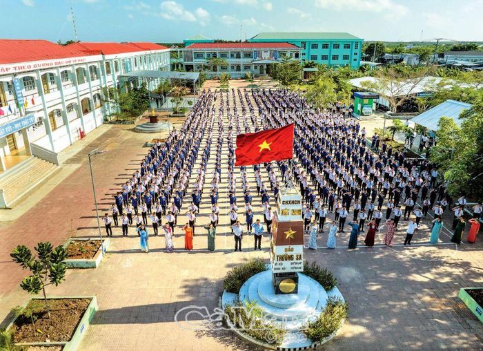 Giáo dục và đào tạo không ngừng phát triển cả về quy mô, chất lượng và hiệu quả. (Trong ảnh: Giờ chào cờ đầu tuần tại Trường THCS Bông Văn Dĩa, thị trấn Rạch Gốc).