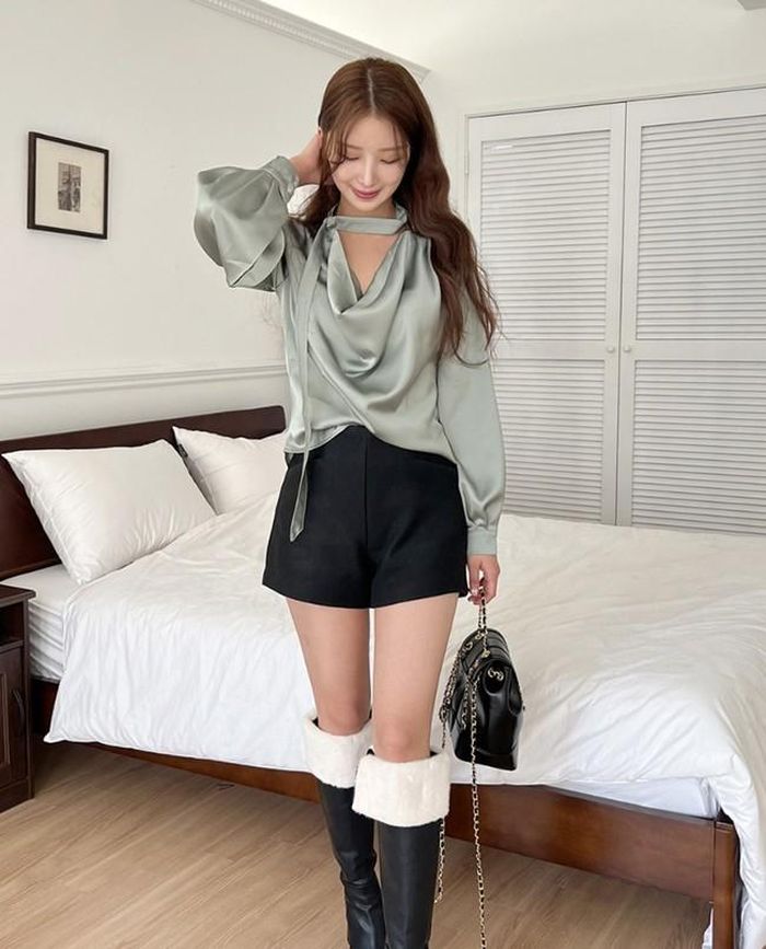Khi cần thanh lịch hóa những mẫu quần short basic, hãy mix thêm áo blouse mềm mại. Set đồ sẽ trở nên hoàn hảo, ấm áp khi bạn gái mang cùng boots dài tới gối.