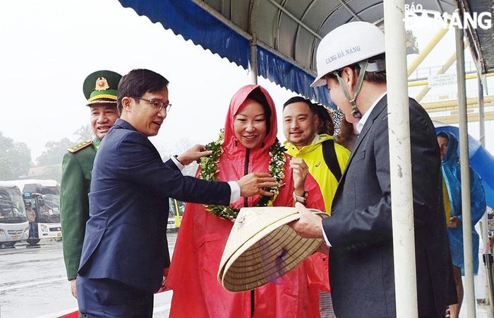 Phó Giám đốc Sở Du lịch Tán Văn Vương (ngoài cùng bên trái) tặng hoa, quà cho những vị khách tàu biển đầu tiên ngày năm mới. Ảnh: THU HÀ
