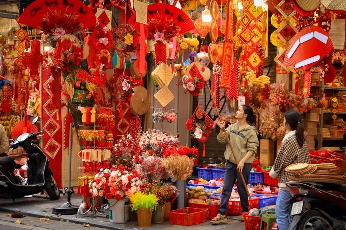  Các tiểu thương tại phố Hàng Mã cho biết ngay sau Noel và Tết dương lịch là các cửa hàng lại tất bật chuẩn bị, trang trí, bày bán đồ phục vụ Tết Nguyên đán. (Ảnh: Hoài Nam/Vietnam+) 