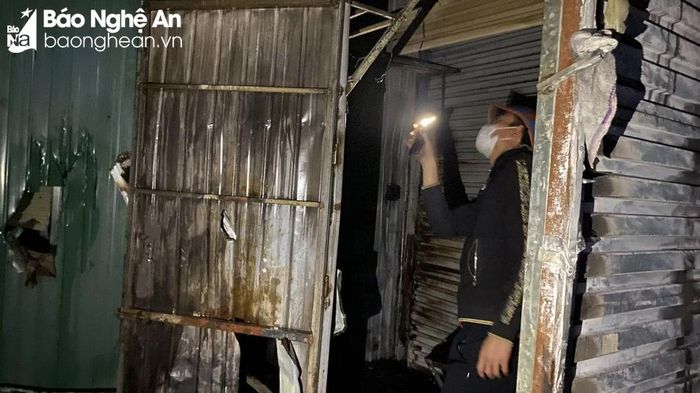  Một số tiểu thương phải tranh thủ kiểm tra xem ki ốt của gia đình có bị cháy lan hay không. Ảnh: Q.A 