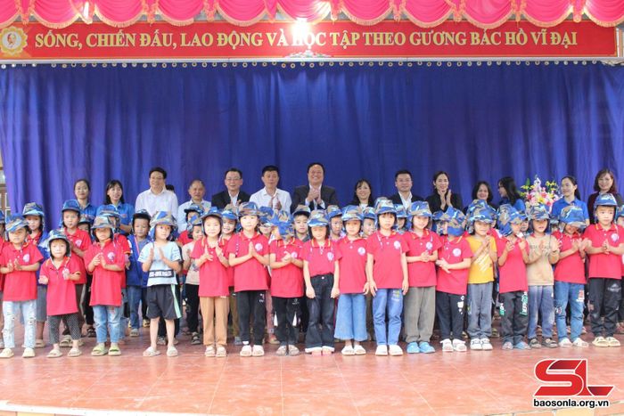 Các đại biểu trao mũ ấm cho học sinh Trường tiểu học xã Tông Cọ.
