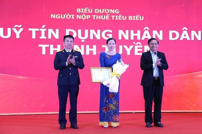Tổng cục trưởng Mai Xuân Thành và Chủ tịch HĐND tỉnh Bình Dương Nguyễn Văn Lộc trao Giấy khen của Tổng cục trưởng Tổng cục Thuế cho Quỹ tín dụng Nhân dân Thanh Tuyền. (Ảnh: Bùi Dương)