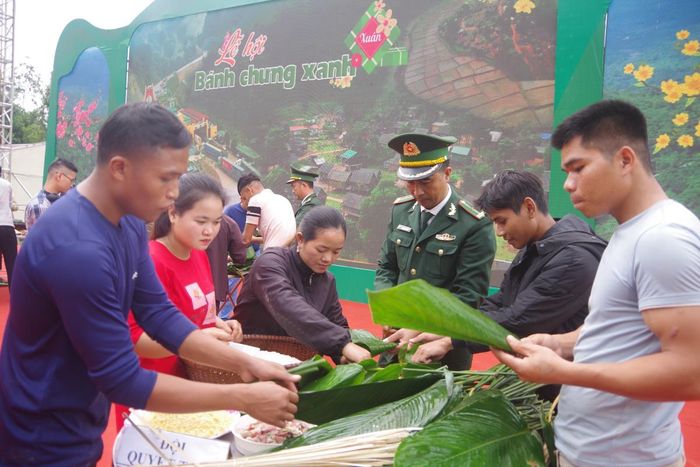 Người dân địa phương và cán bộ Biên phòng thi gói bánh chưng. Ảnh: Viết Lam
