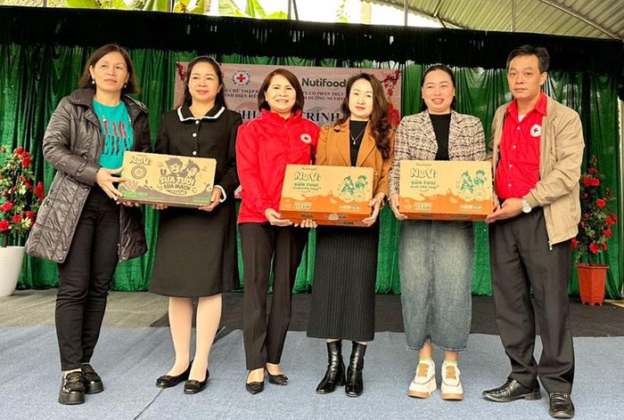 Lãnh đạo Hội Chữ thập đỏ tỉnh, Phòng Giáo dục và Đào tạo huyện Mường Nhé và đại diện nhà tài trợ trao tặng sữa cho học sinh huyện Mường Nhé.