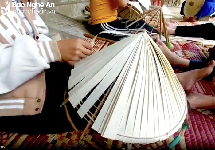  Sau đó, lá nón được để trên tấm kính rồi dùng lưỡi lam cắt thành những đoạn có kích thước bằng nhau. Sau đó, người thợ sẽ tiến hành xếp lá vào khung. Ảnh: Thanh Phúc 