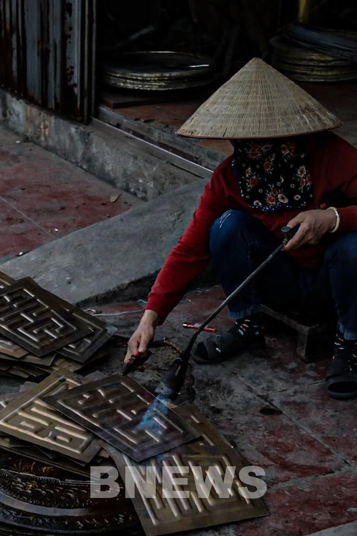Ngày nay, ảnh hưởng của thị trường nên số lượng sản phẩm chạm bạc ở đây giảm dần. Người làm nghề chỉ nhận sản xuất theo số lượng đặt, còn chủ yếu chuyển sang làm đồ đồng dạng bán công nghiệp. Ảnh: Đức Hạnh/BNEWS/TTXVN