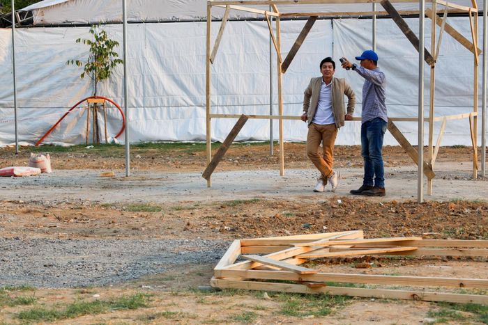 Một chủ cửa hàng đặt sạp tới đây đến trao đổi về tình hình chuẩn bị với người điều hành dự án.