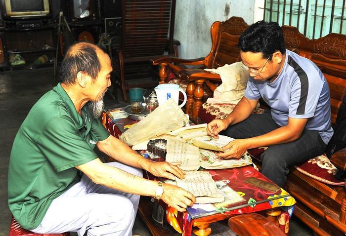Cán bộ Bảo tàng tỉnh khai thác tư liệu chữ viết tại tư gia ông Võ Ngọc Lâm-thành viên Ban nghi lễ đình Tân Tạo. Ảnh: Bá Tính