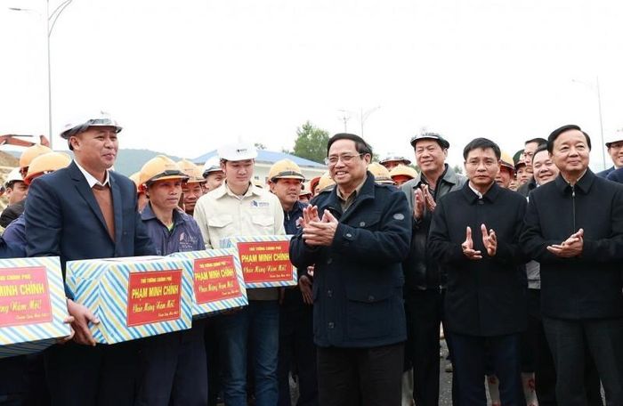 Thủ tướng Phạm Minh Chính động viên, chúc mừng năm mới tới kỹ sư, công nhân thi công hầm Thung Thi thuộc Dự án thành phần Cao tốc Mai Sơn-Quốc lộ 45. (Ảnh: Dương Giang/TTXVN)