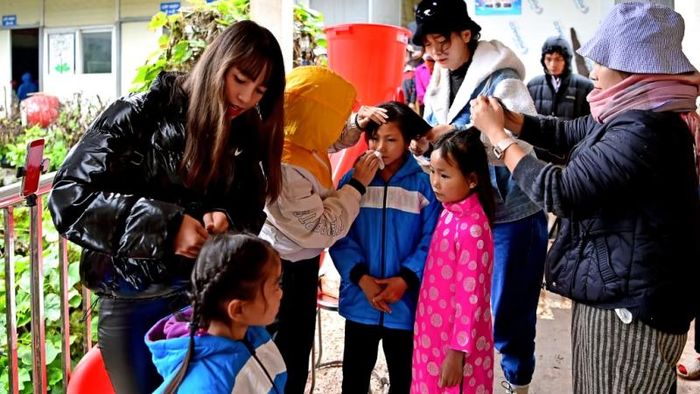 Các thành viên đoàn thiện nguyện Đồng Bào Việt “làm đẹp” cho các em nhỏ vùng cao.
